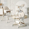 Beige baby high chair and swing set in a room with a neutral color scheme.